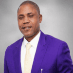 Portrait of Prince Ade Ajayi wearing a purple suit, white shirt and cream tie, representing the cultural leadership behind Ekiti’s World Iyan Carnival.