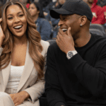 Sola and Peter seated together at a public event, sharing a moment of laughter and closeness.